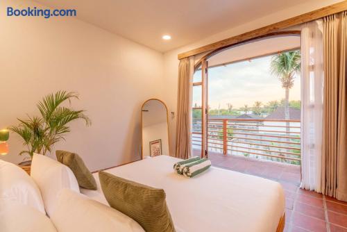 Bright bedroom with private balcony and serene palm-view terrace