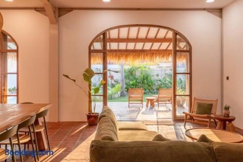 Sunlit living space with arched doors opening to a private tropical patio