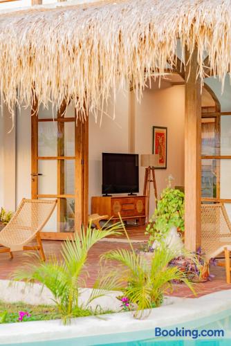 Tropical thatched patio with poolside seating and cozy indoor-outdoor living