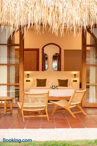 Tropical suite with private terrace, thatched roof, and cozy lounge seating
