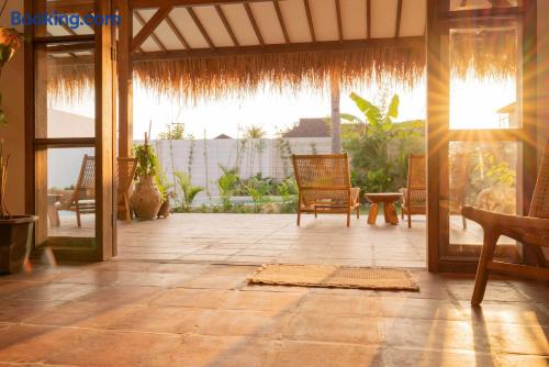 Sunlit tropical patio with open-air living and garden views