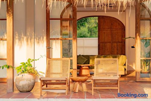 Sunlit tropical terrace with woven lounge chairs and cozy indoor-outdoor seating