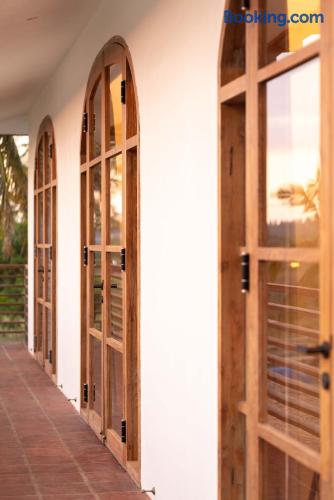Charming arched wooden doors along a serene, sunlit terrace walkway