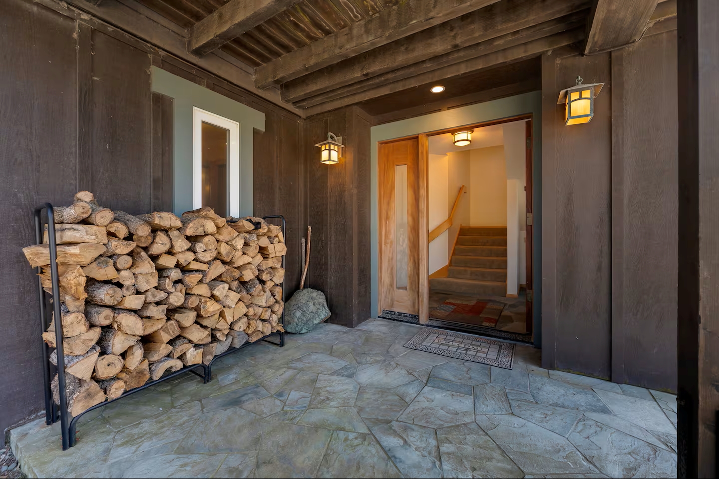 Rustic covered entry with warm lighting and cozy cabin charm