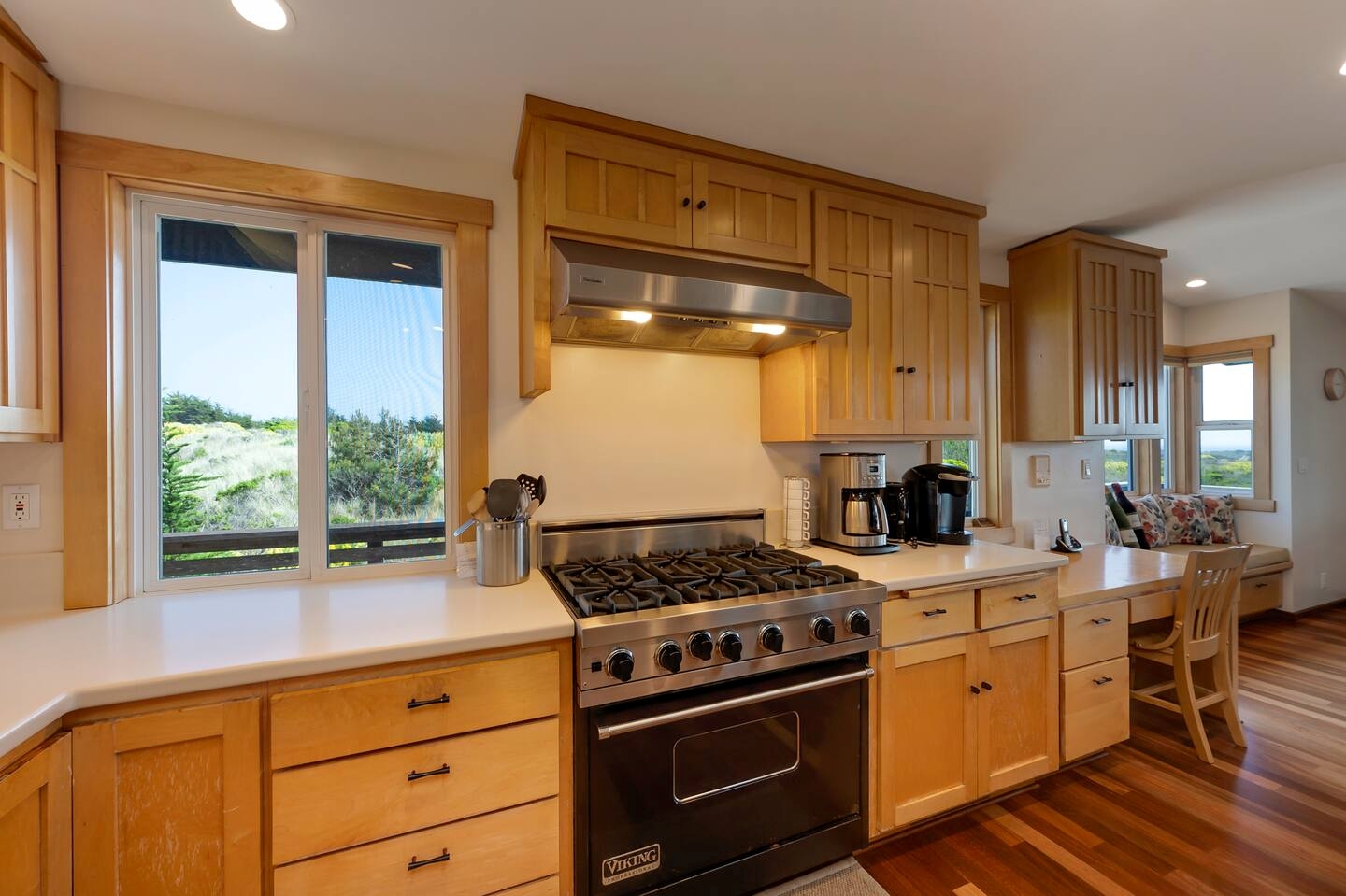 Bright gourmet kitchen with gas range, scenic views, and cozy breakfast bar