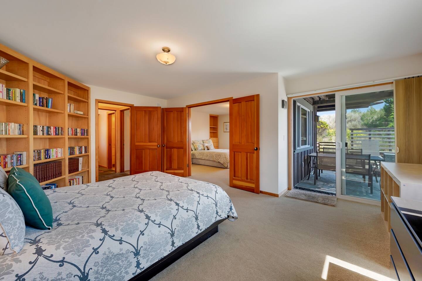 Spacious bedroom with built-in bookshelves and private patio access