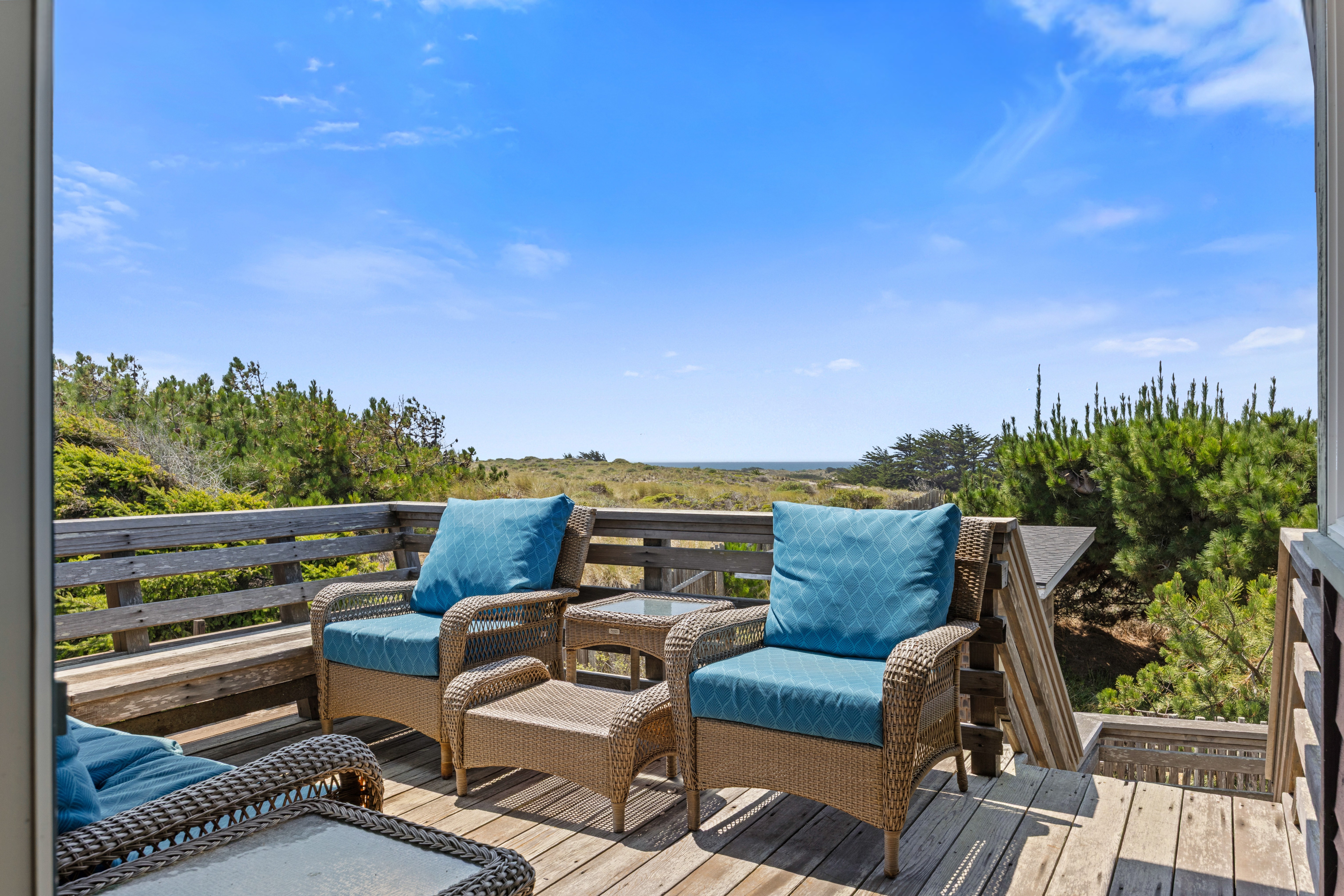 Relax on the sunny deck with cozy seating and peaceful ocean views