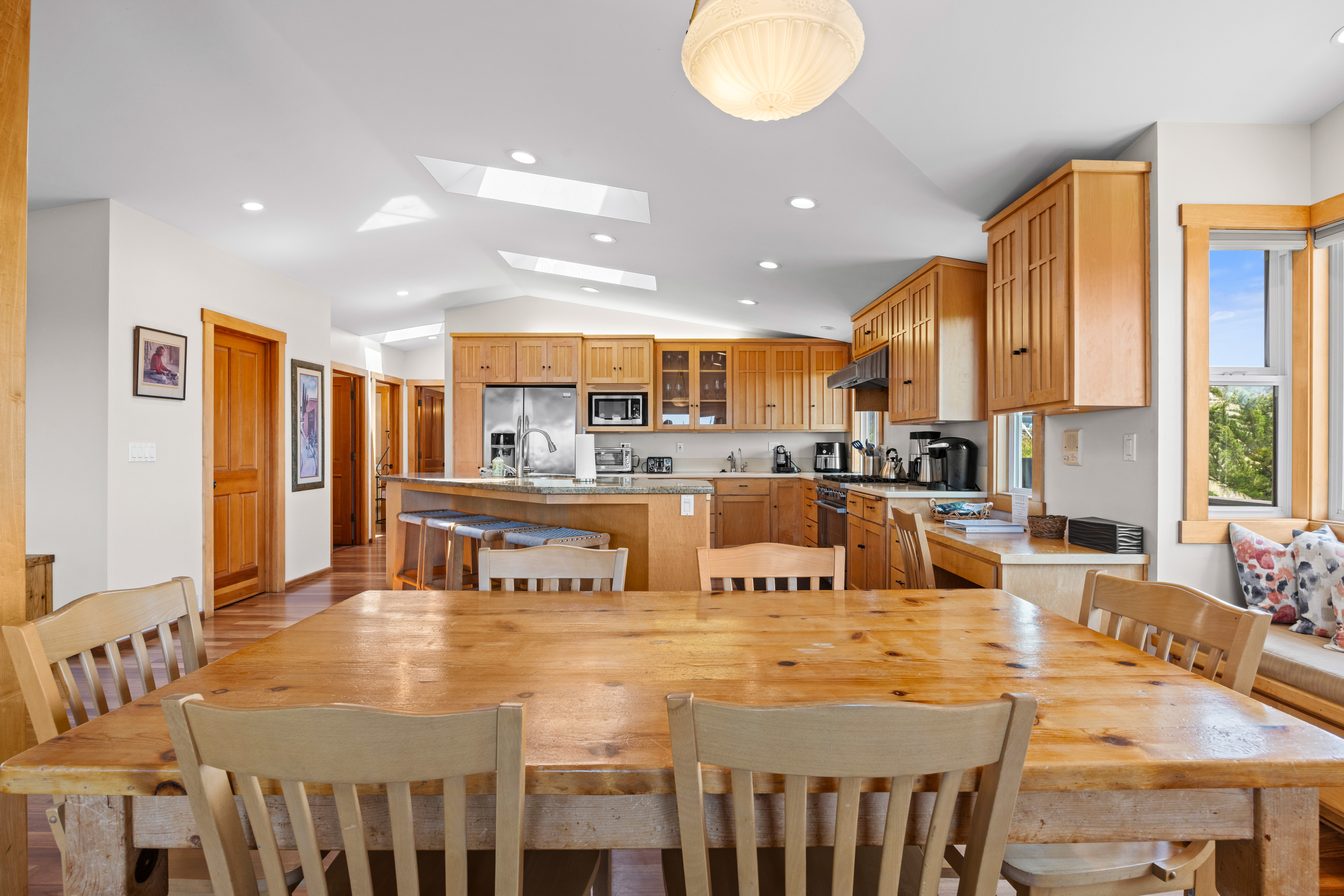 Bright open kitchen and dining space with island seating and skylights