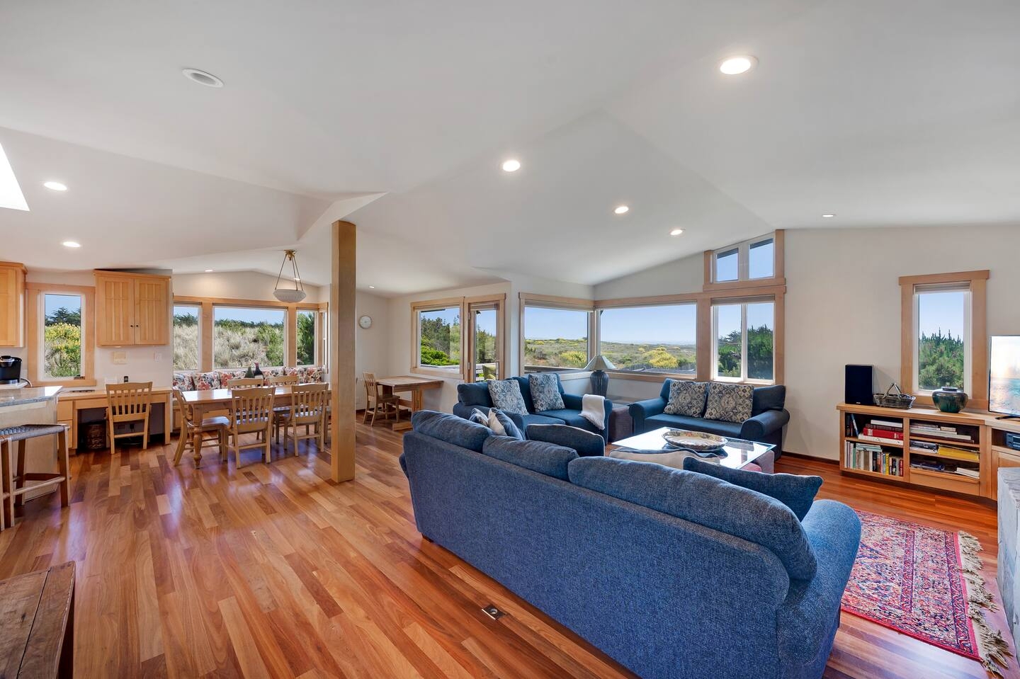 Bright open living space with hardwood floors and scenic wraparound views