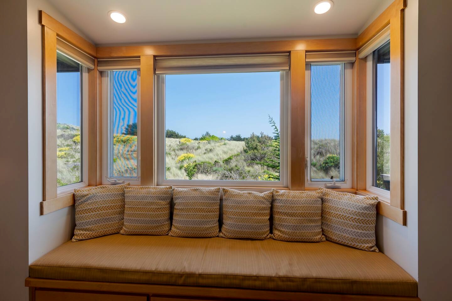 Sunny window seat with serene dune views and a cozy built-in bench