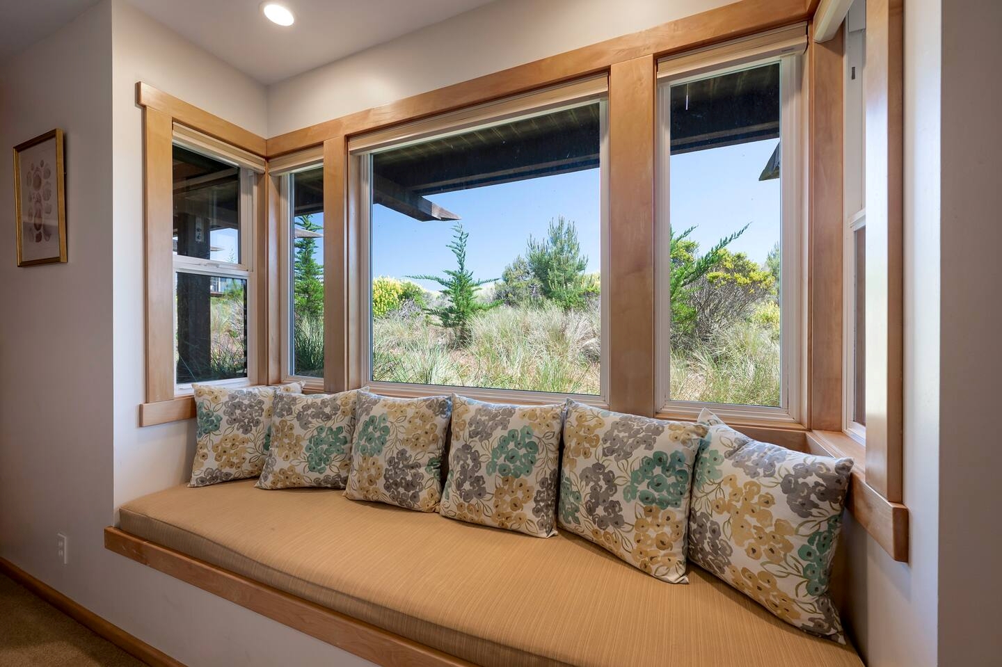 Sunny window seat with plush pillows and serene nature views