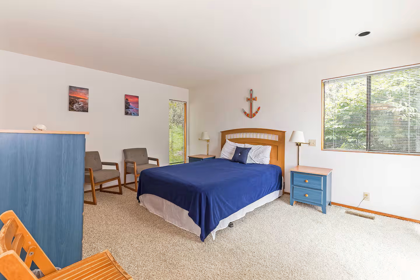 Bright, spacious bedroom with cozy seating and peaceful nature views
