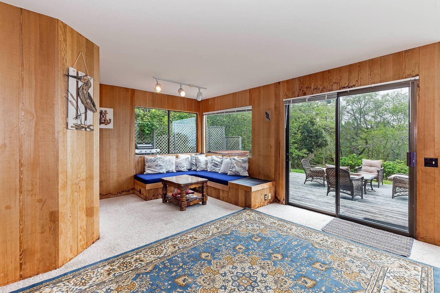 Cozy wood-paneled lounge with deck access and peaceful forest views