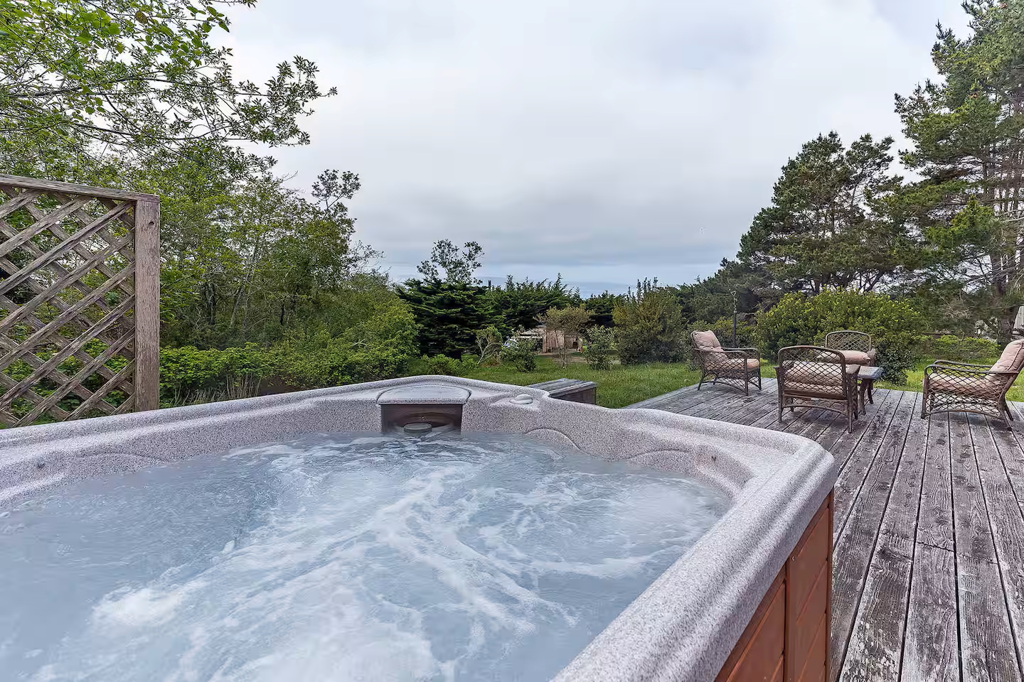 Private hot tub and sunny deck surrounded by peaceful garden views