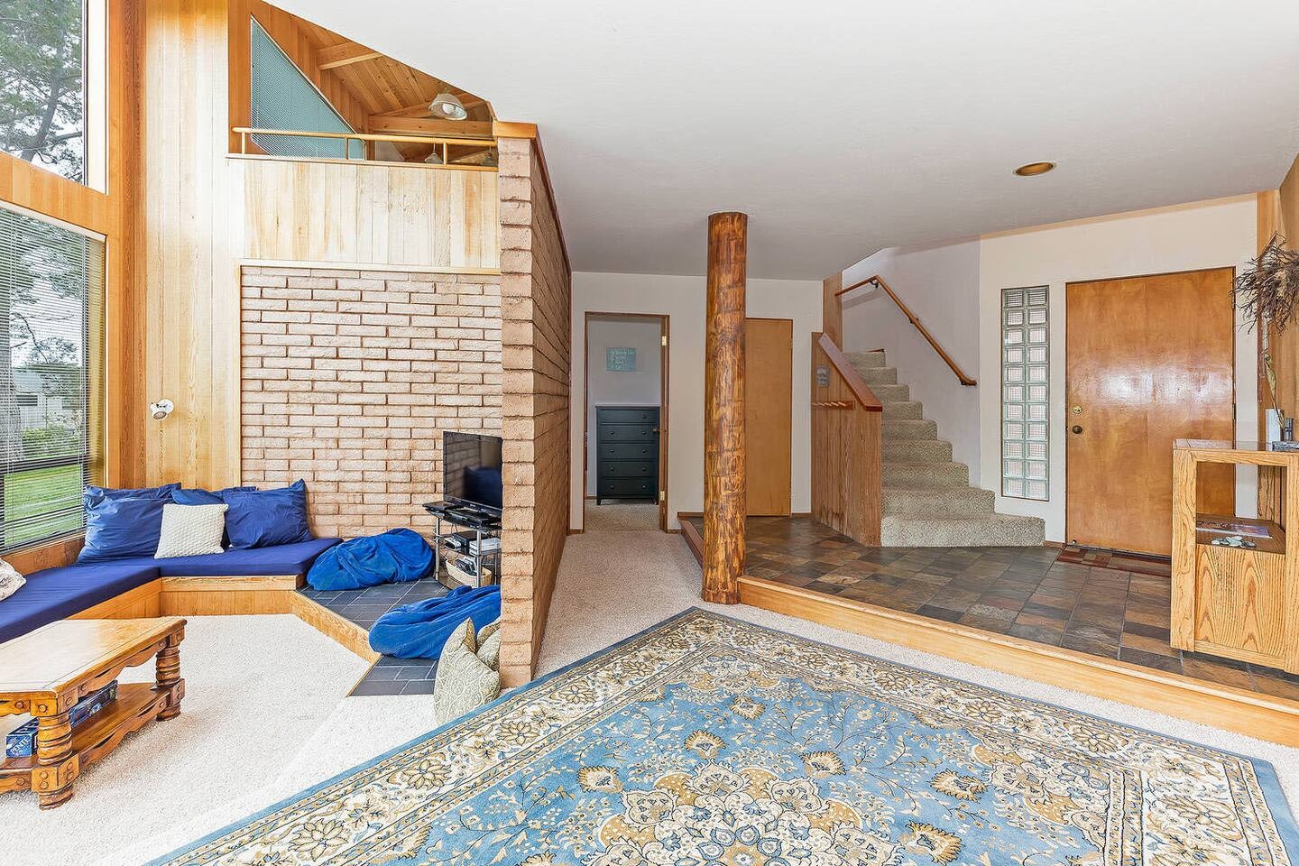 Bright split-level living room with soaring windows and cozy built-in seating