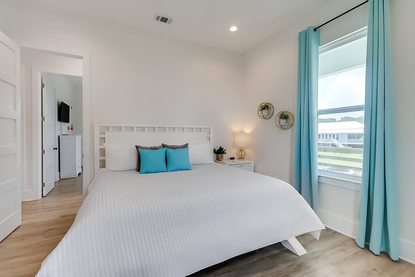 Bedroom with teal curtains and king bed