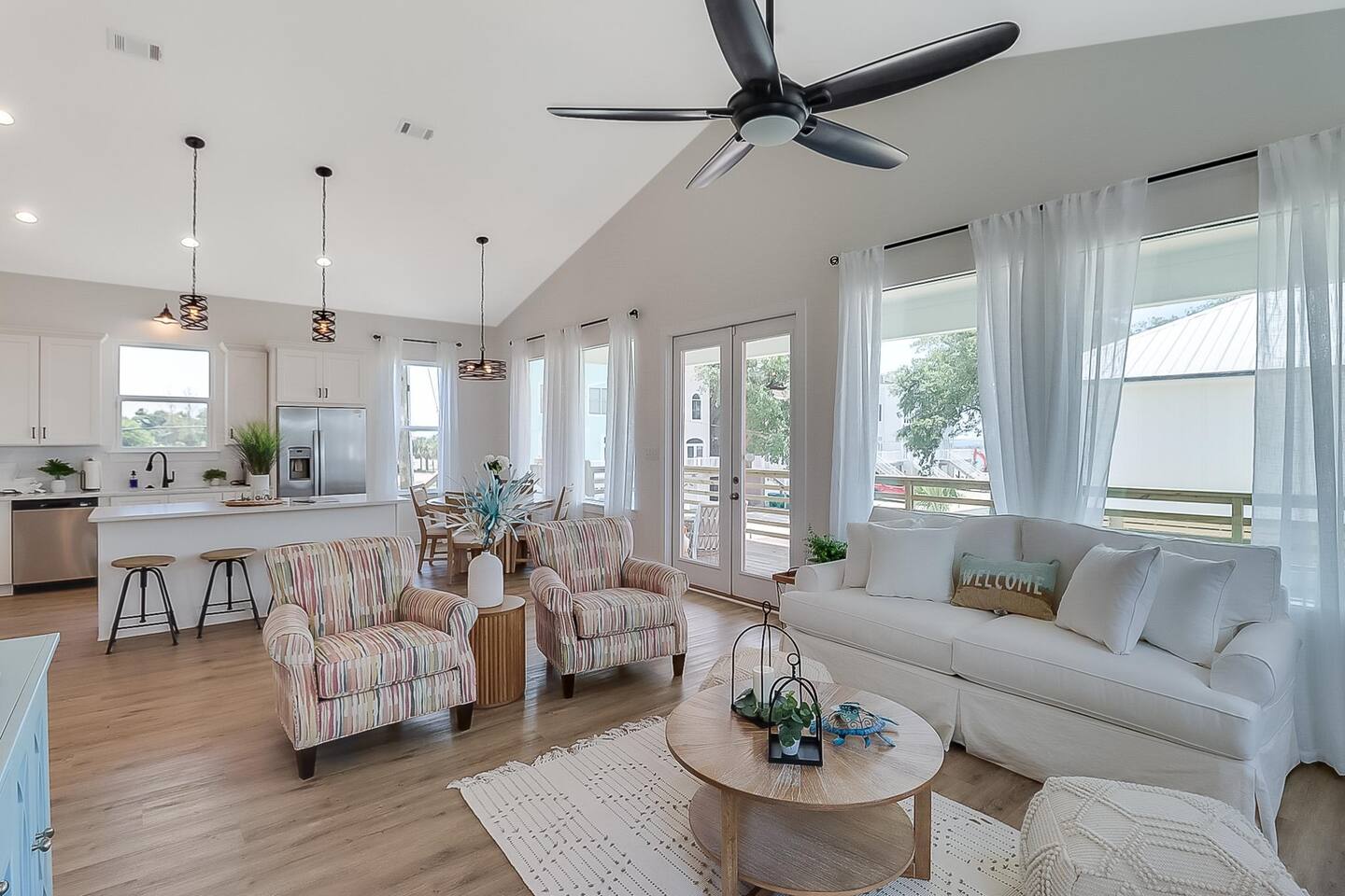 Bright living room with ceiling fan and big windows