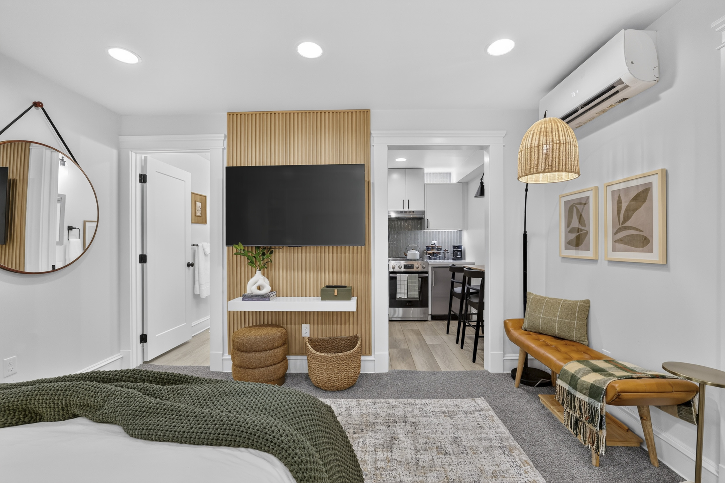 Bright modern studio with kitchenette, TV wall, and stylish seating area