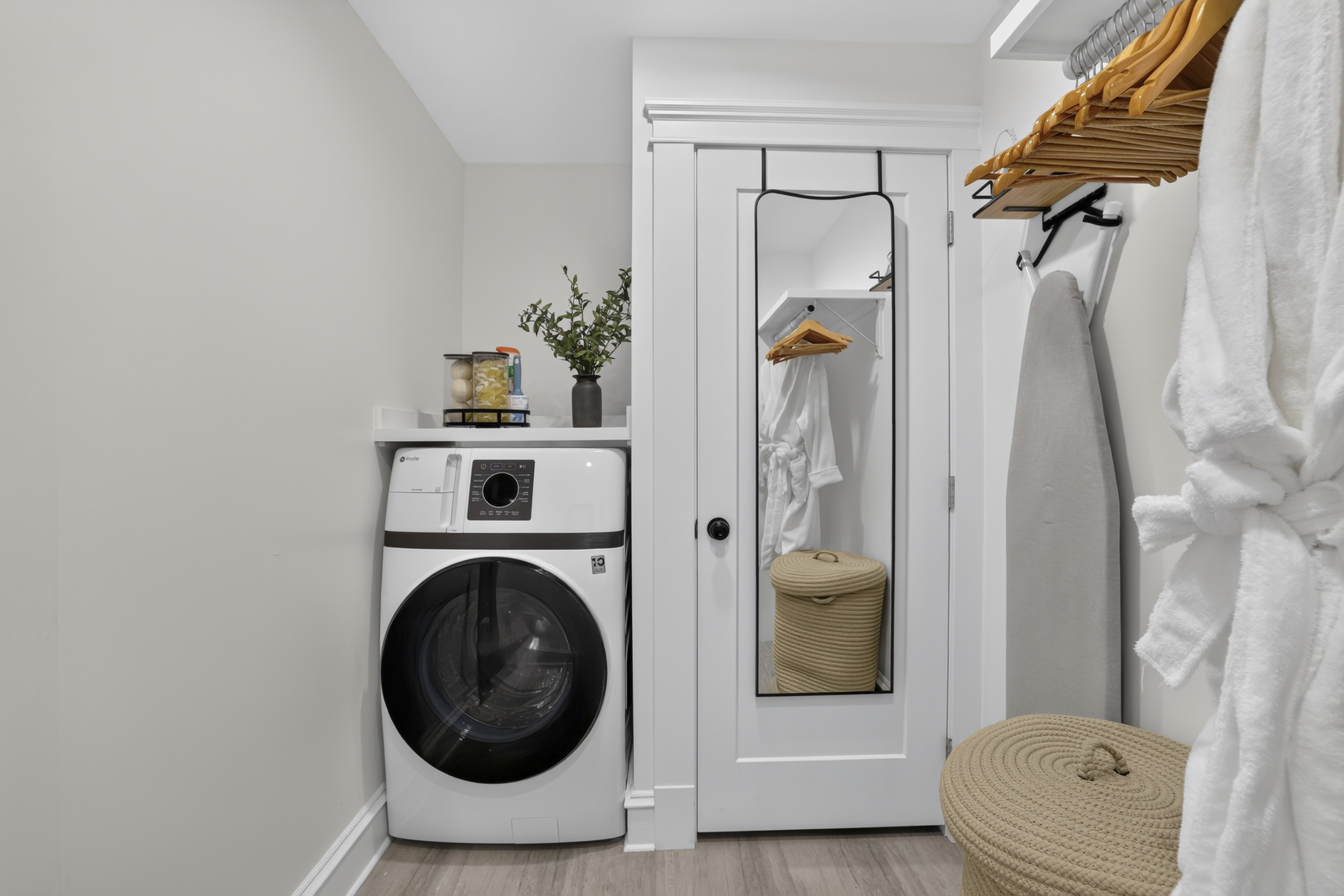 Convenient in-unit laundry nook with robes, storage, and full-length mirror