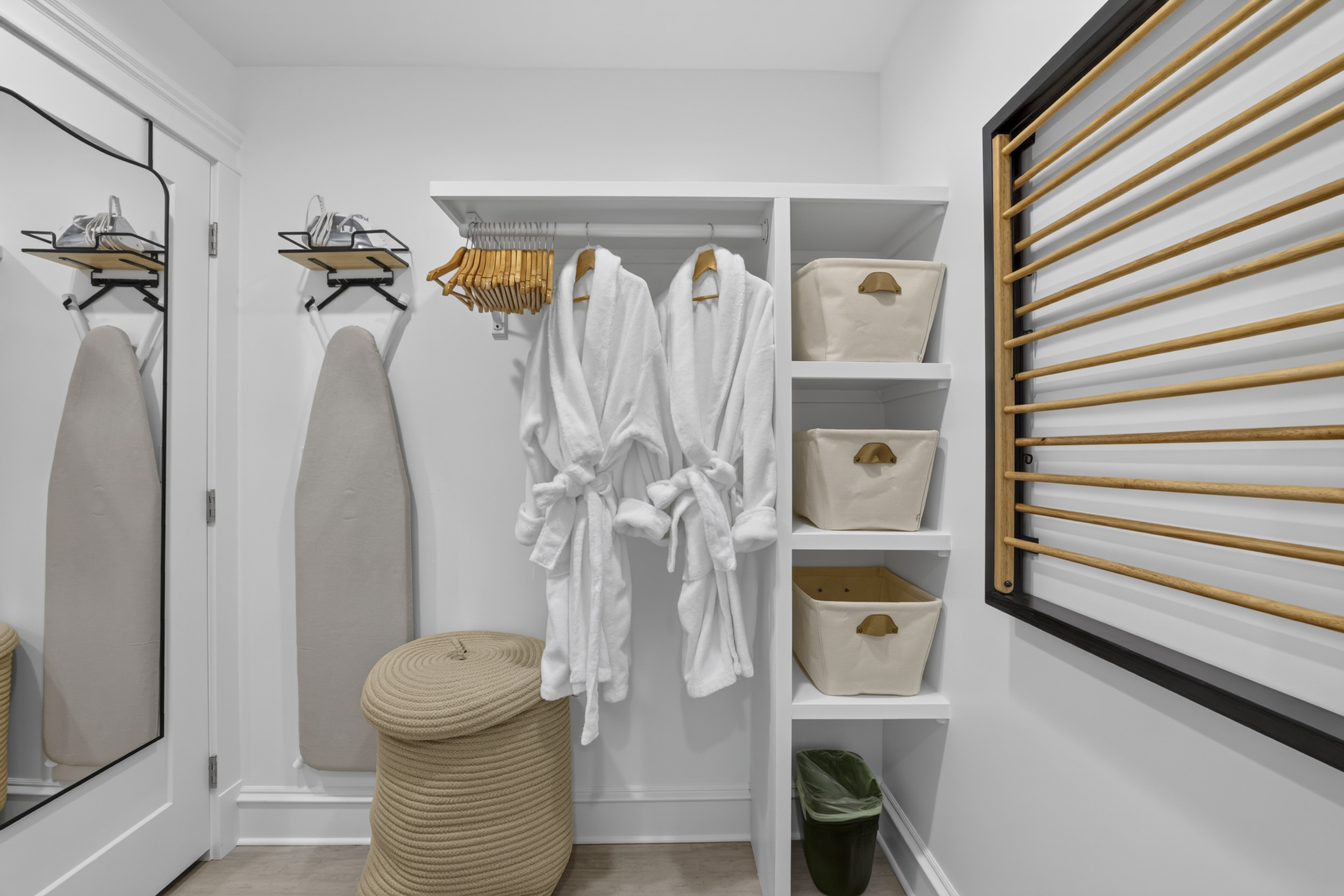 Thoughtfully stocked dressing area with robes, storage, and built-in shelving