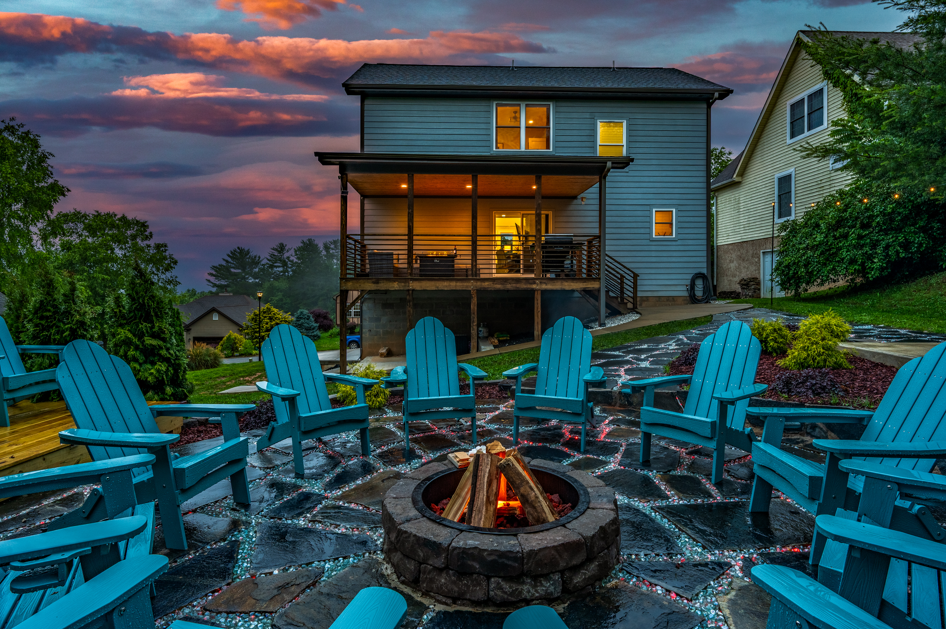 Twilight backyard oasis with fire pit