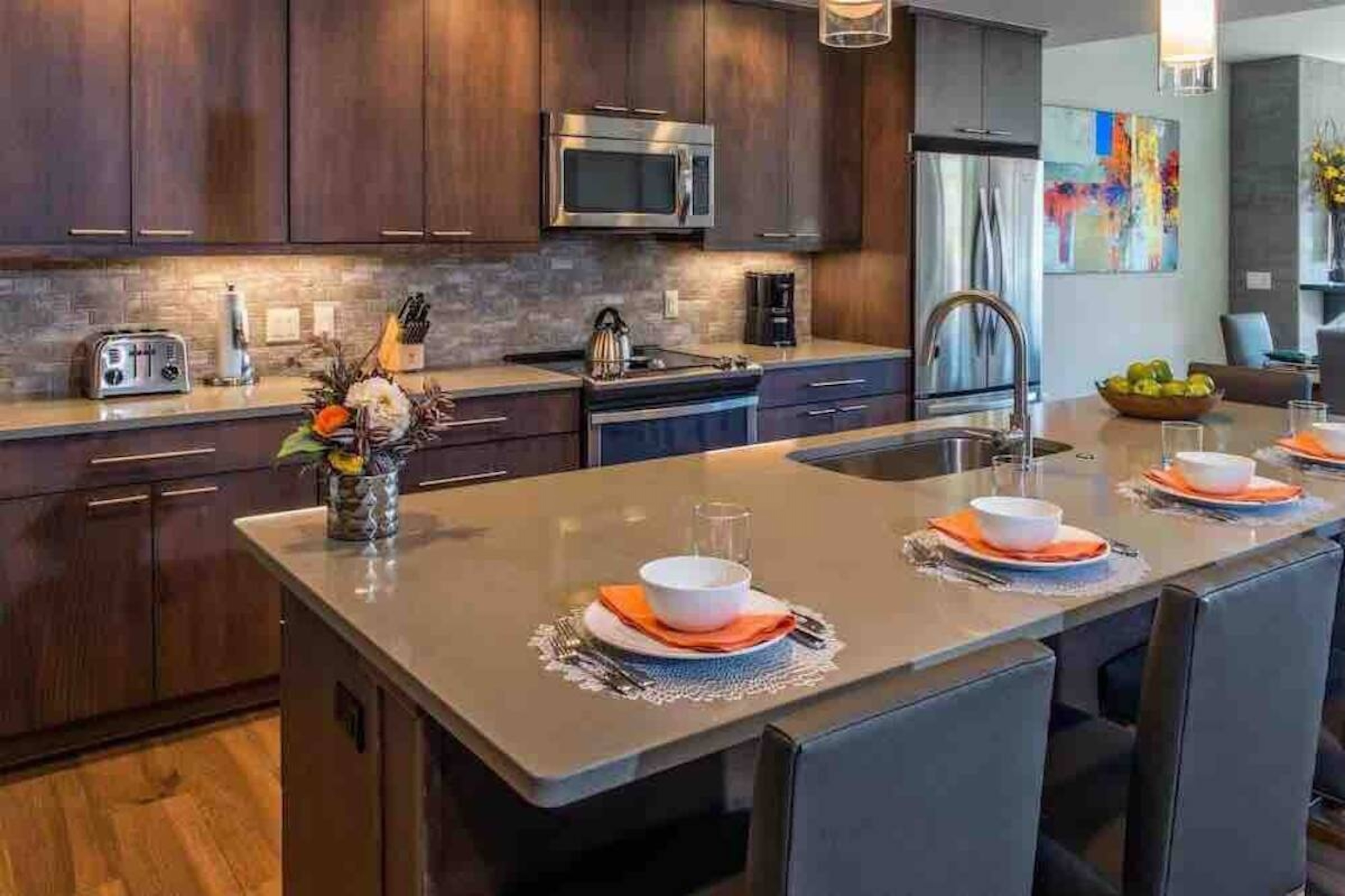 Modern gourmet kitchen with large island seating and stainless appliances