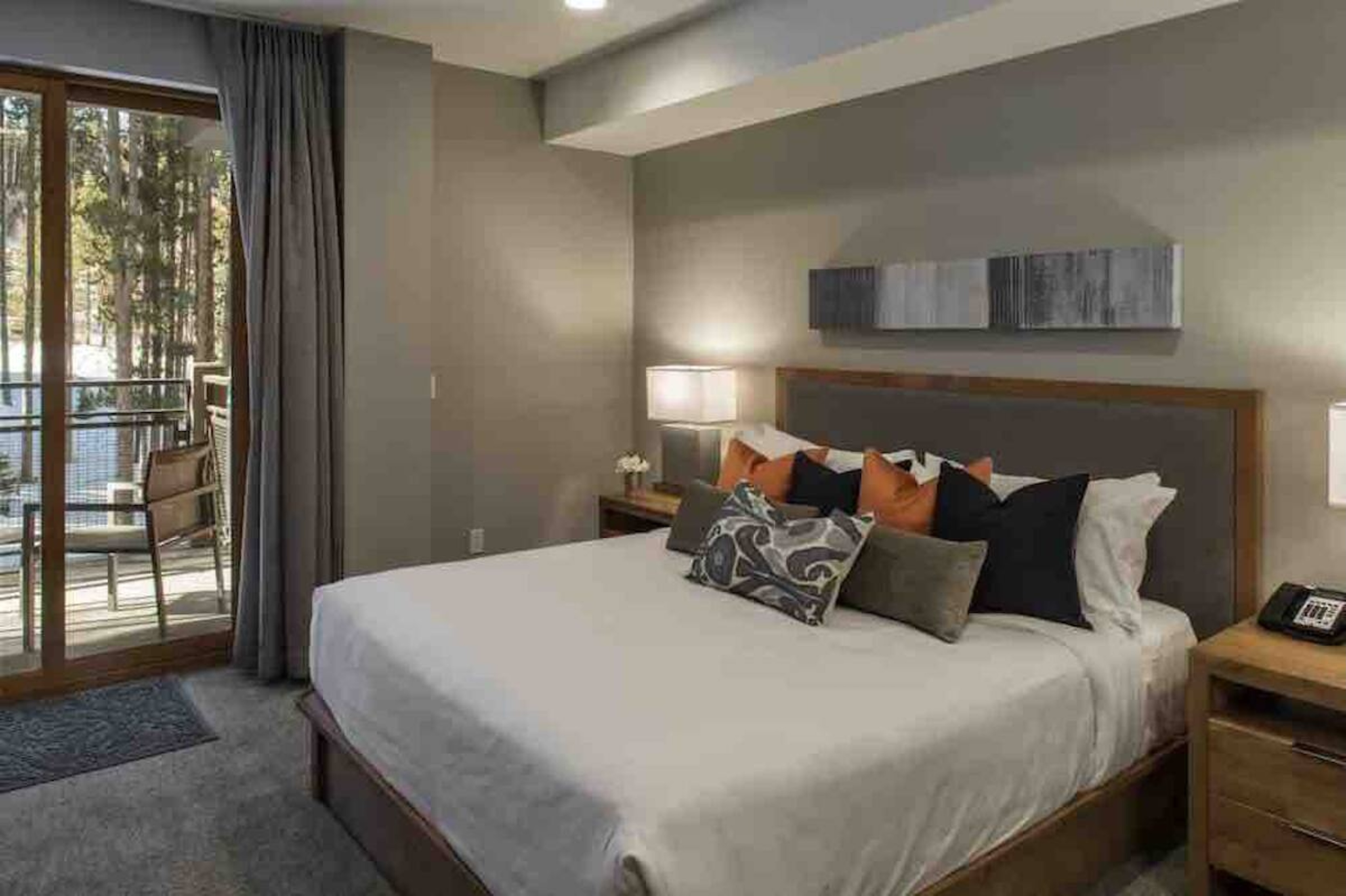 Cozy modern bedroom with private balcony and serene forest views