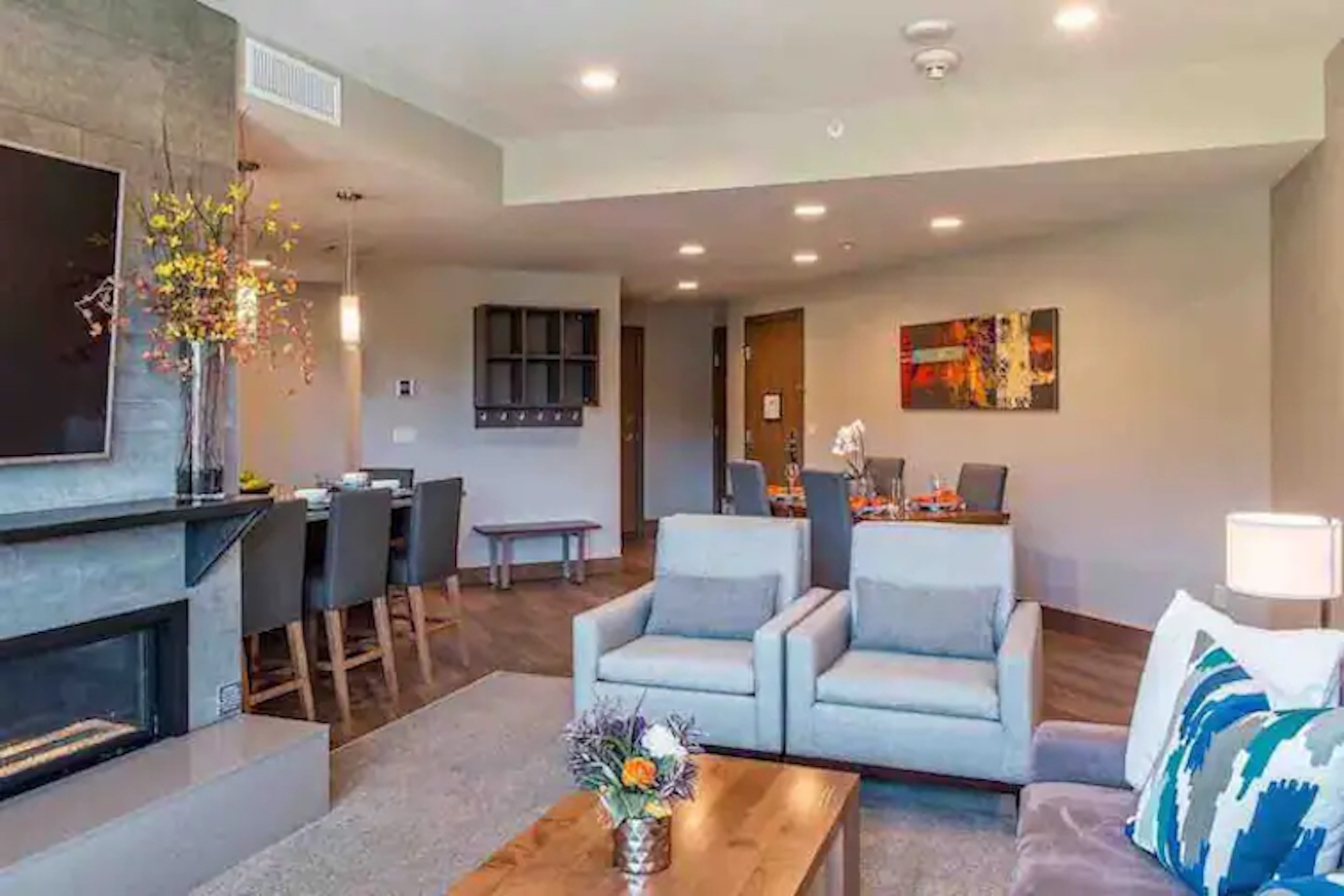 Modern open living space with fireplace, dining area, and cozy seating
