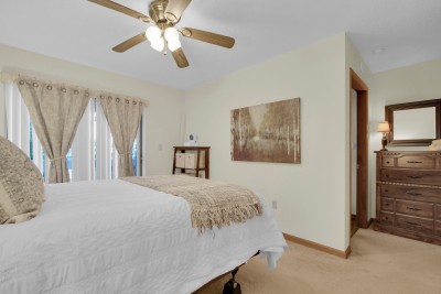 Retreat to a bright, inviting bedroom featuring plush bedding and warm wood accents, all bathed in natural light — the perfect blend of comfort and mountain charm for a restful night’s sleep.