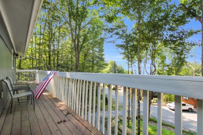 Unwind on the tree-lined private balcony, where comfortable seating invites you to slow down and soak in peaceful wooded views — a serene escape for quiet mornings and starlit evenings.