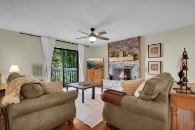 Unwind in a stunning living room warmed by a soaring stone fireplace, then step onto your private balcony to soak in sweeping mountain views — the perfect blend of comfort and breathtaking scenery.