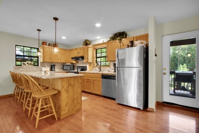 Cook up mountain favorites in the bright wood kitchen, where island seating invites easy conversation and effortless deck access welcomes in fresh air for indoor-outdoor mountain living.