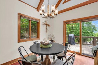 Soak in forest views from this bright dining nook, where vaulted ceilings and deck access make every meal feel like an occasion—morning coffee to sunset dinners, mountains as your backdrop