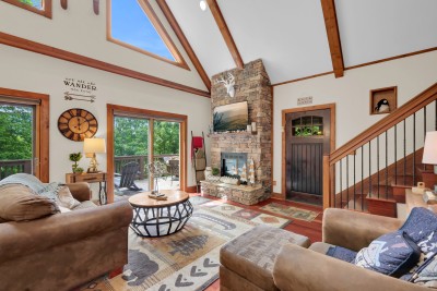 Gather in this mountain-style living room, where a stone fireplace sets the scene and deck access invites you to step right out into the scenic views—perfect for warming up after a day of adventure.