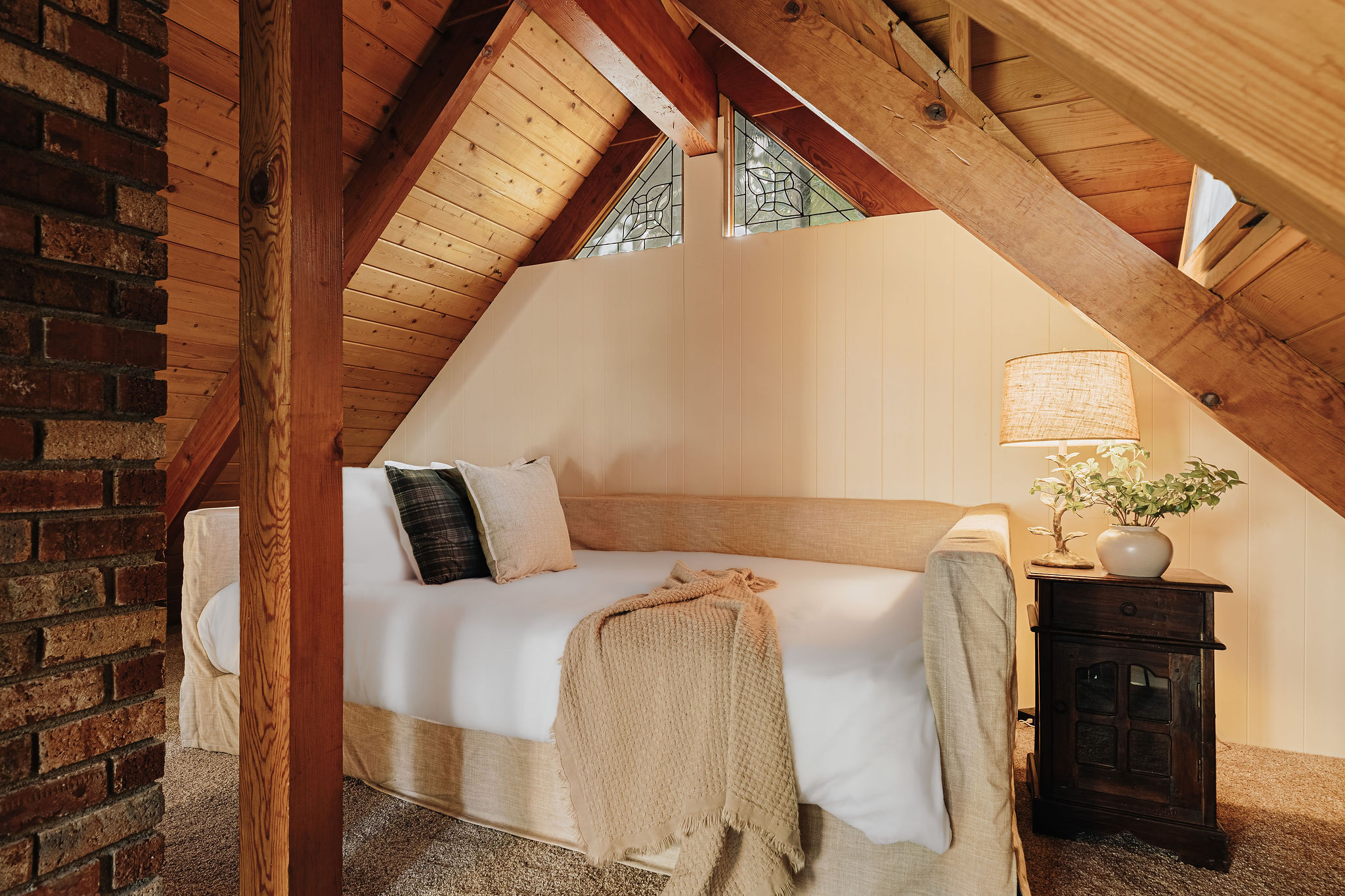 Cozy loft nook with rustic beams, soft lighting, and inviting cabin charm