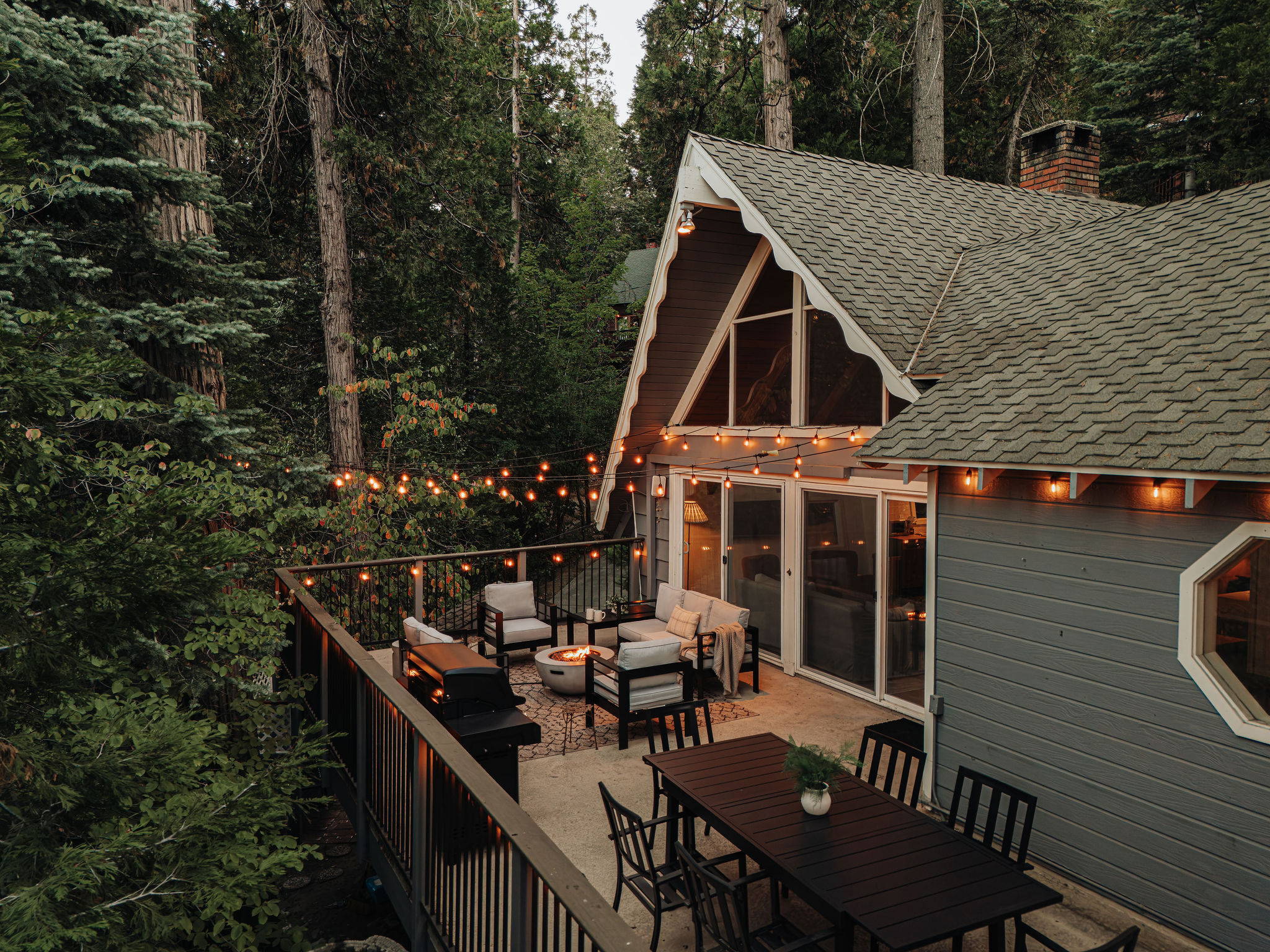 Cozy forest cabin with a spacious deck, fire pit, and glowing string lights