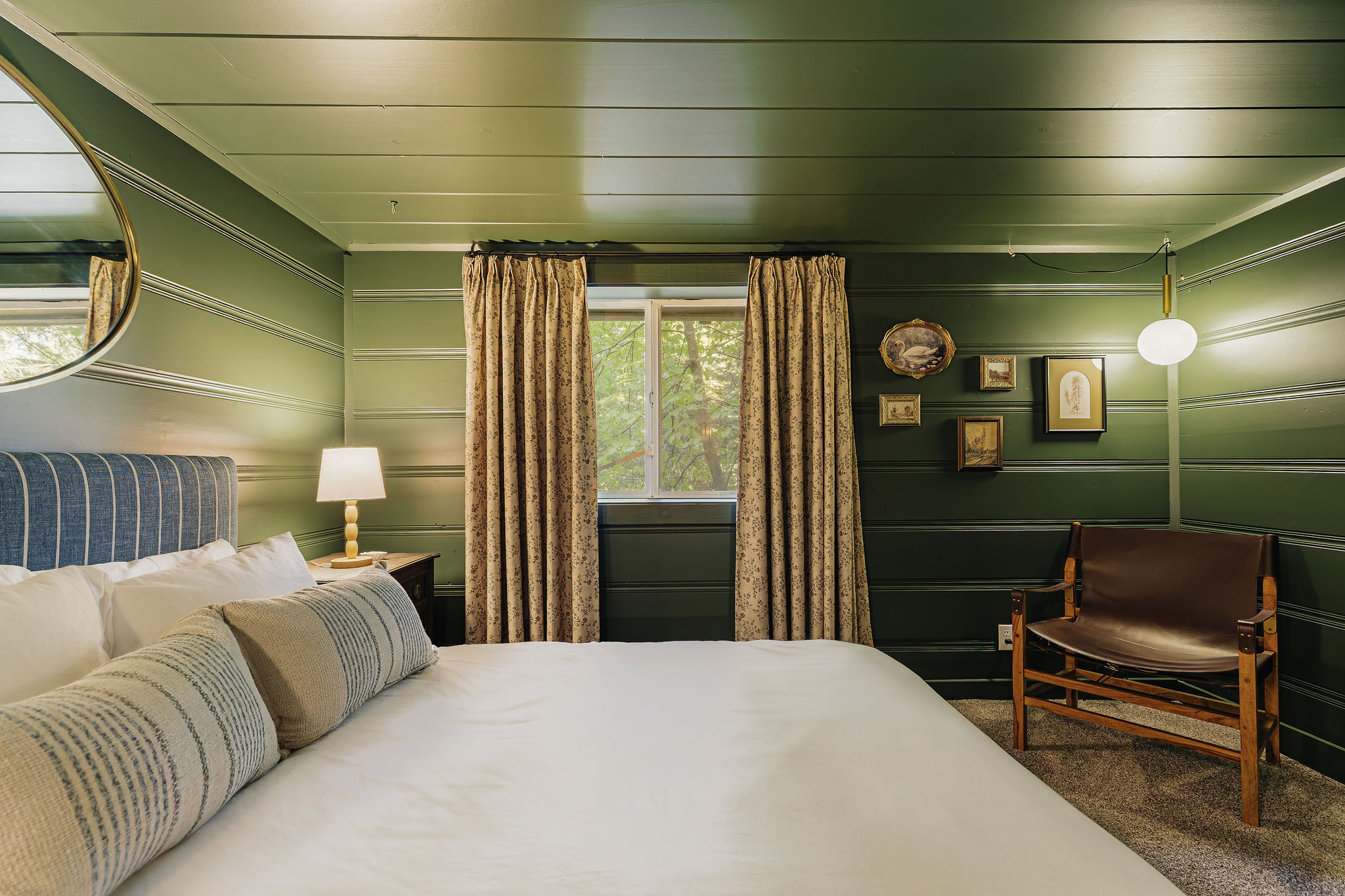 Moody green bedroom with plush bedding and cozy boutique-cabin charm