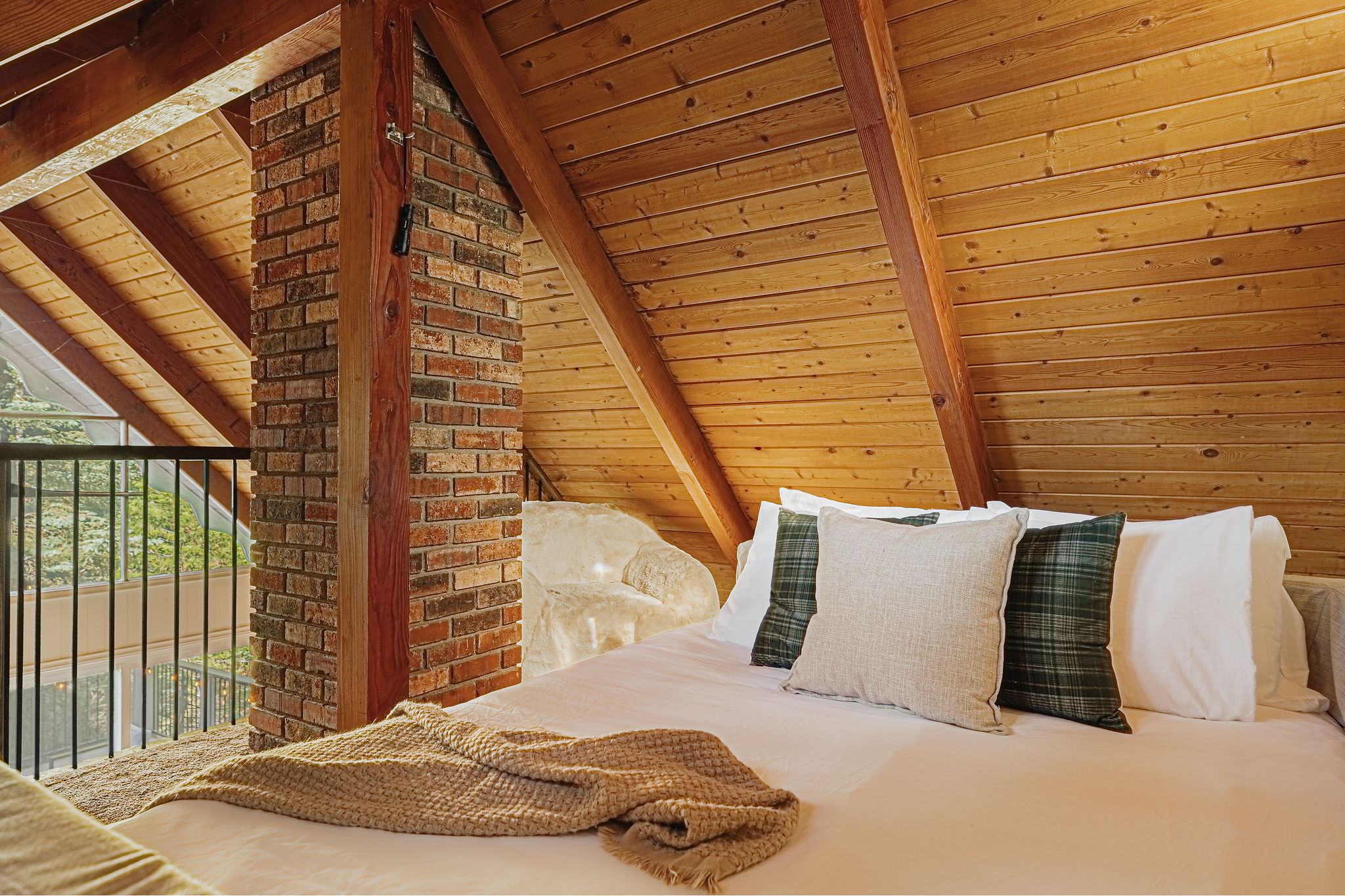 Cozy loft bedroom with vaulted wood ceilings and rustic cabin charm