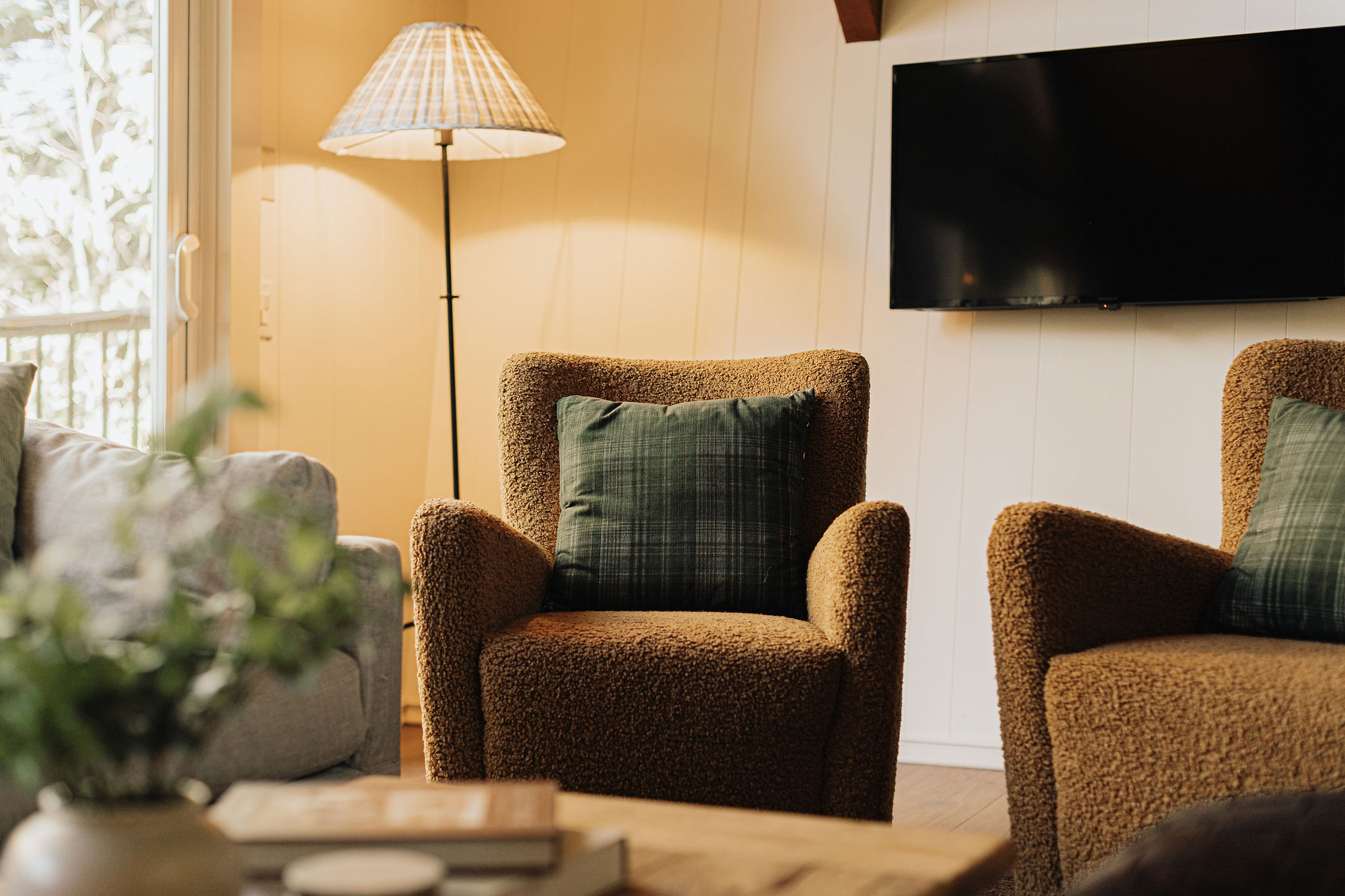 Cozy lounge with plush seating, warm lighting, and TV