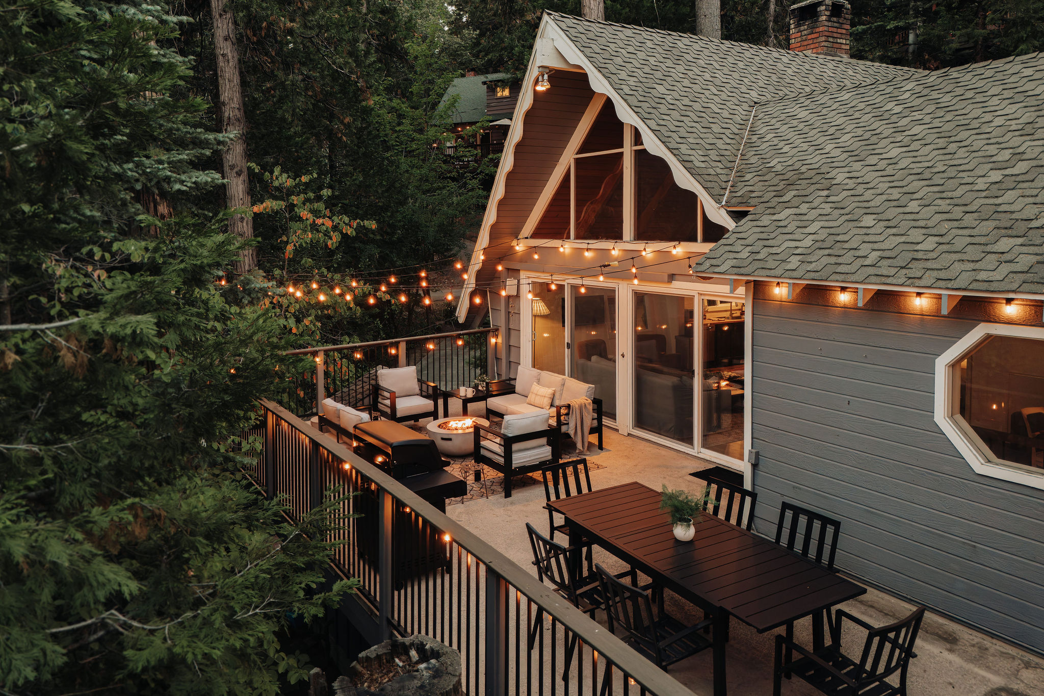 Cozy forest A-frame with a spacious deck, fire pit, and glowing string lights