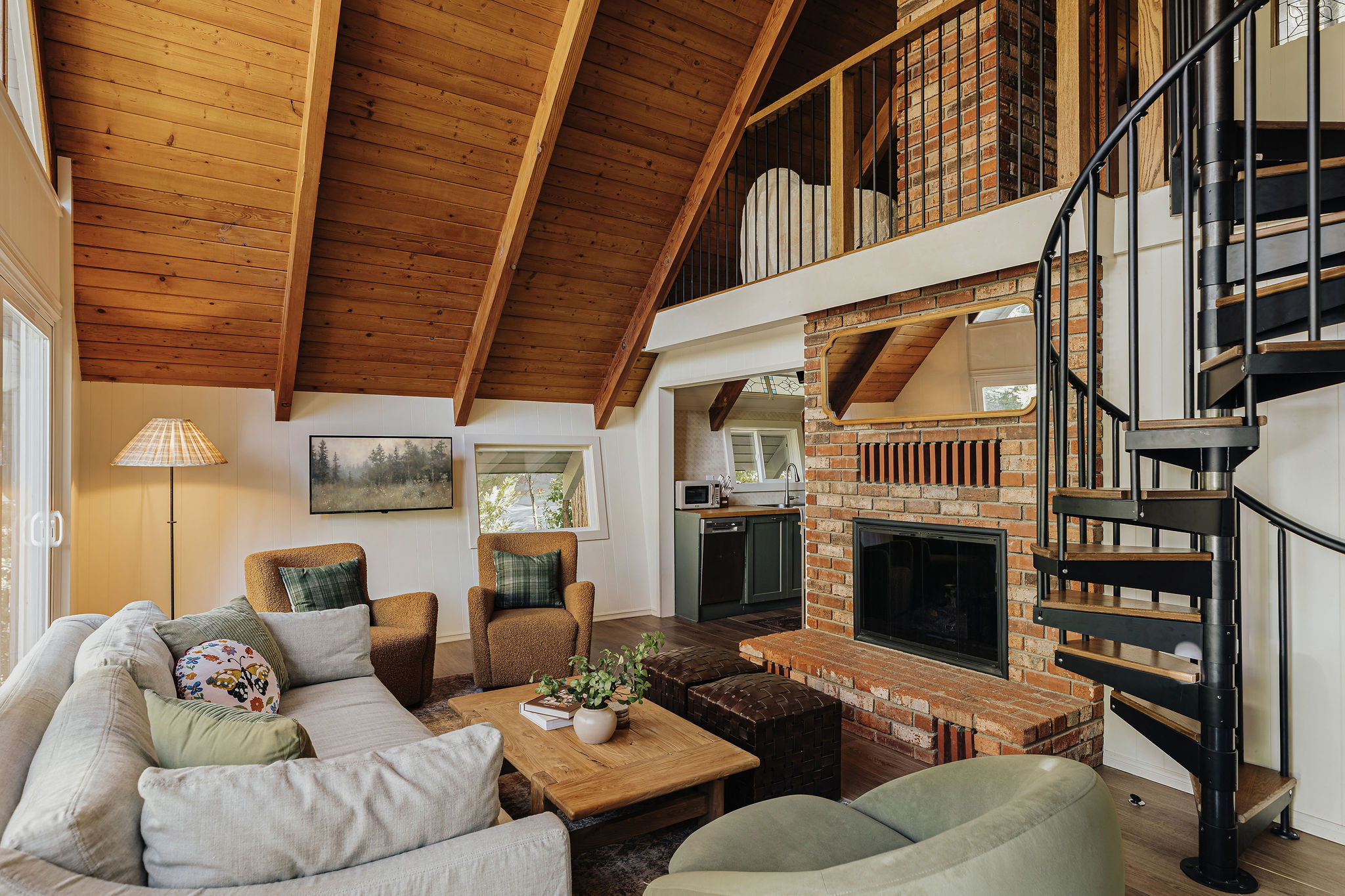Cozy loft living with vaulted wood ceilings, brick fireplace & spiral stairs