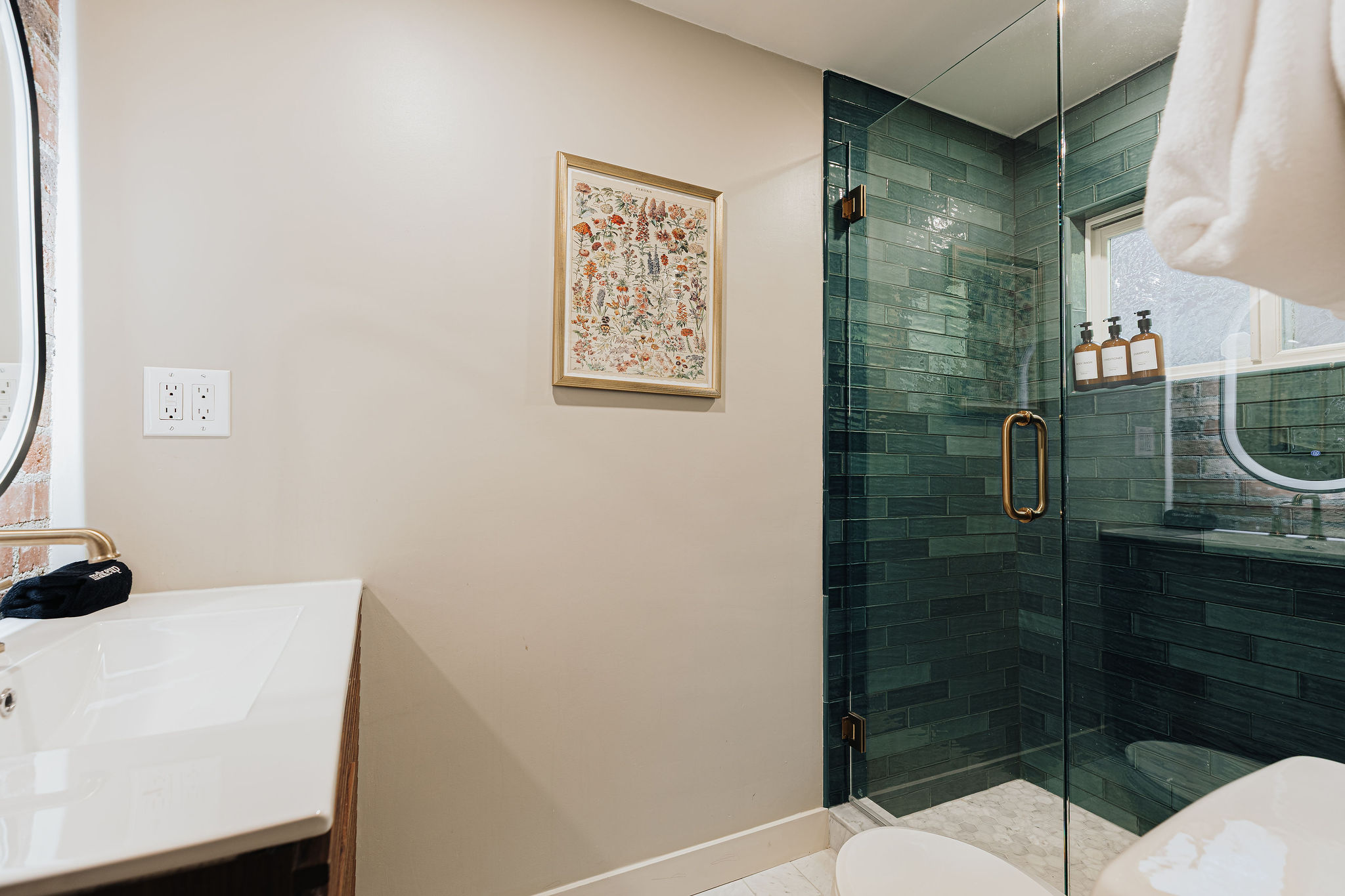 Modern bath with teal-tiled walk-in shower and bright natural light