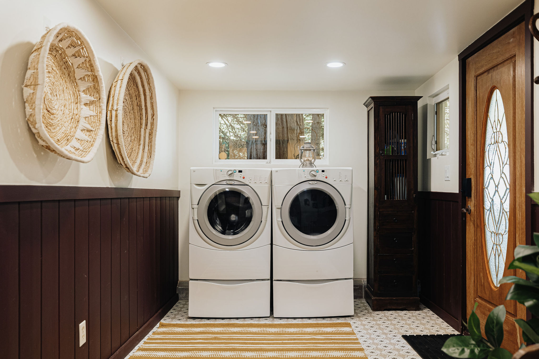 Bright entry laundry room with full-size washer, dryer, and stylish details