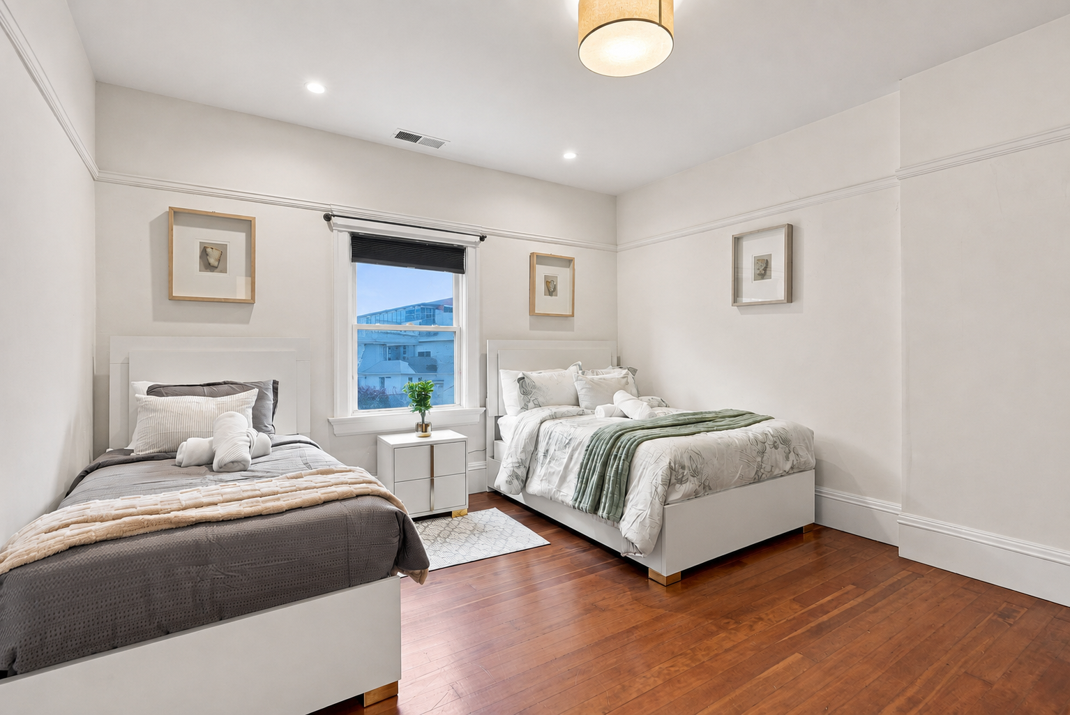 Bright double bedroom with hardwood floors and stylish, calming decor
