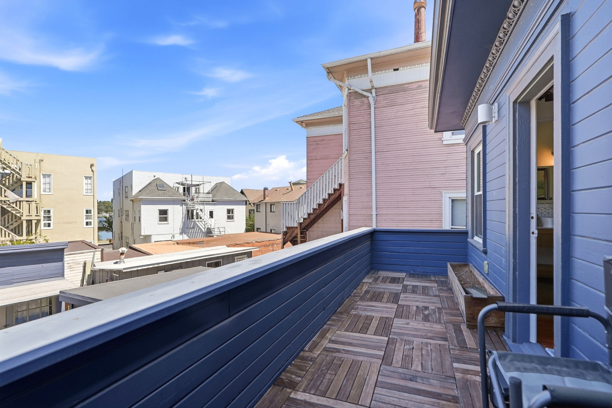 Private balcony with stylish flooring and charming neighborhood views