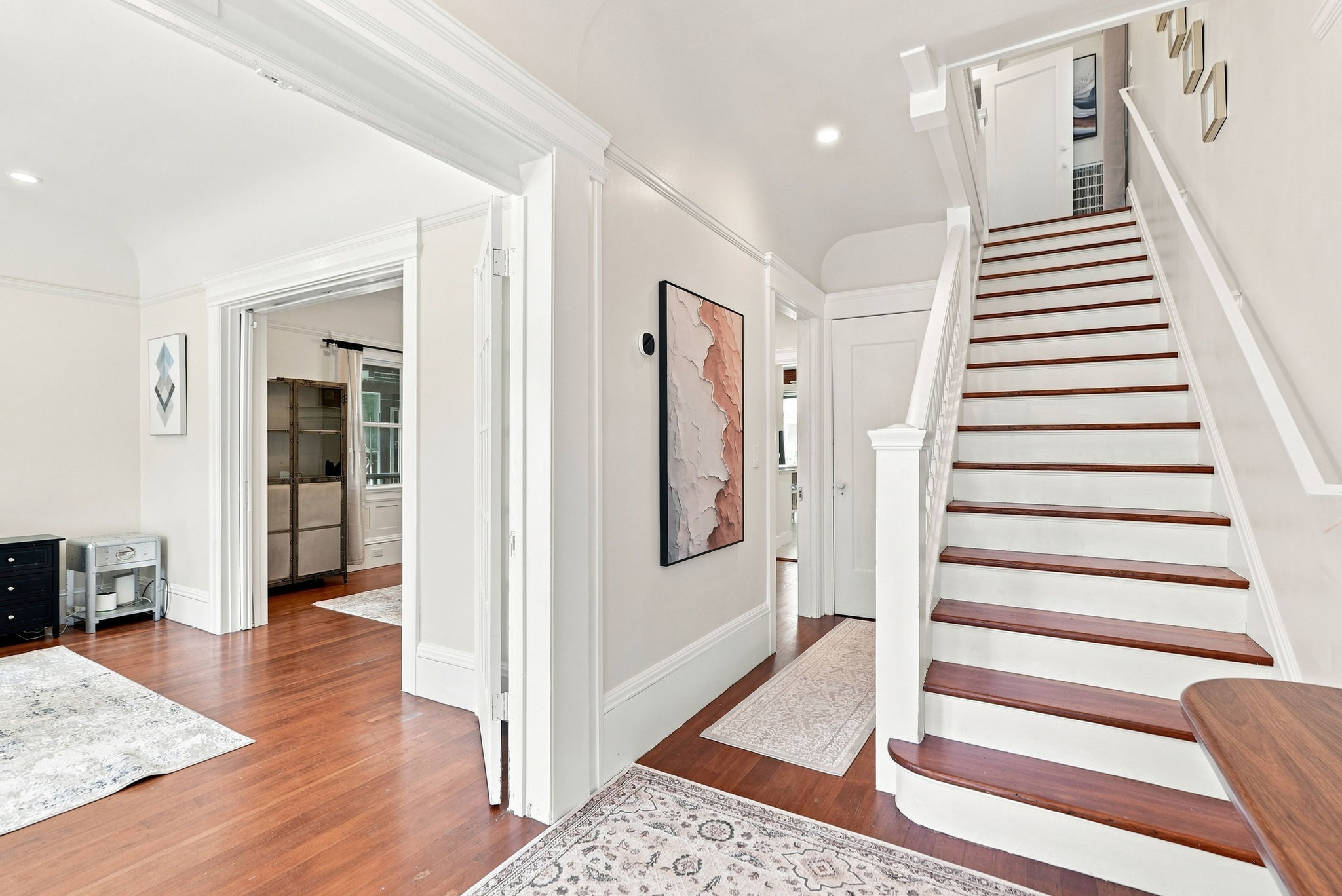 Bright, elegant entryway with grand staircase and hardwood floors