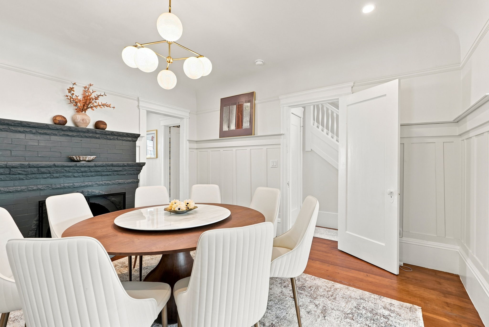 Elegant dining room with fireplace, globe chandelier, and seating for six