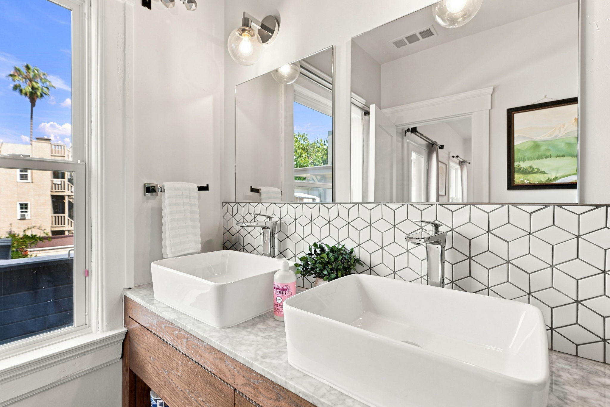 Bright modern double-vanity bathroom with designer tile and natural light