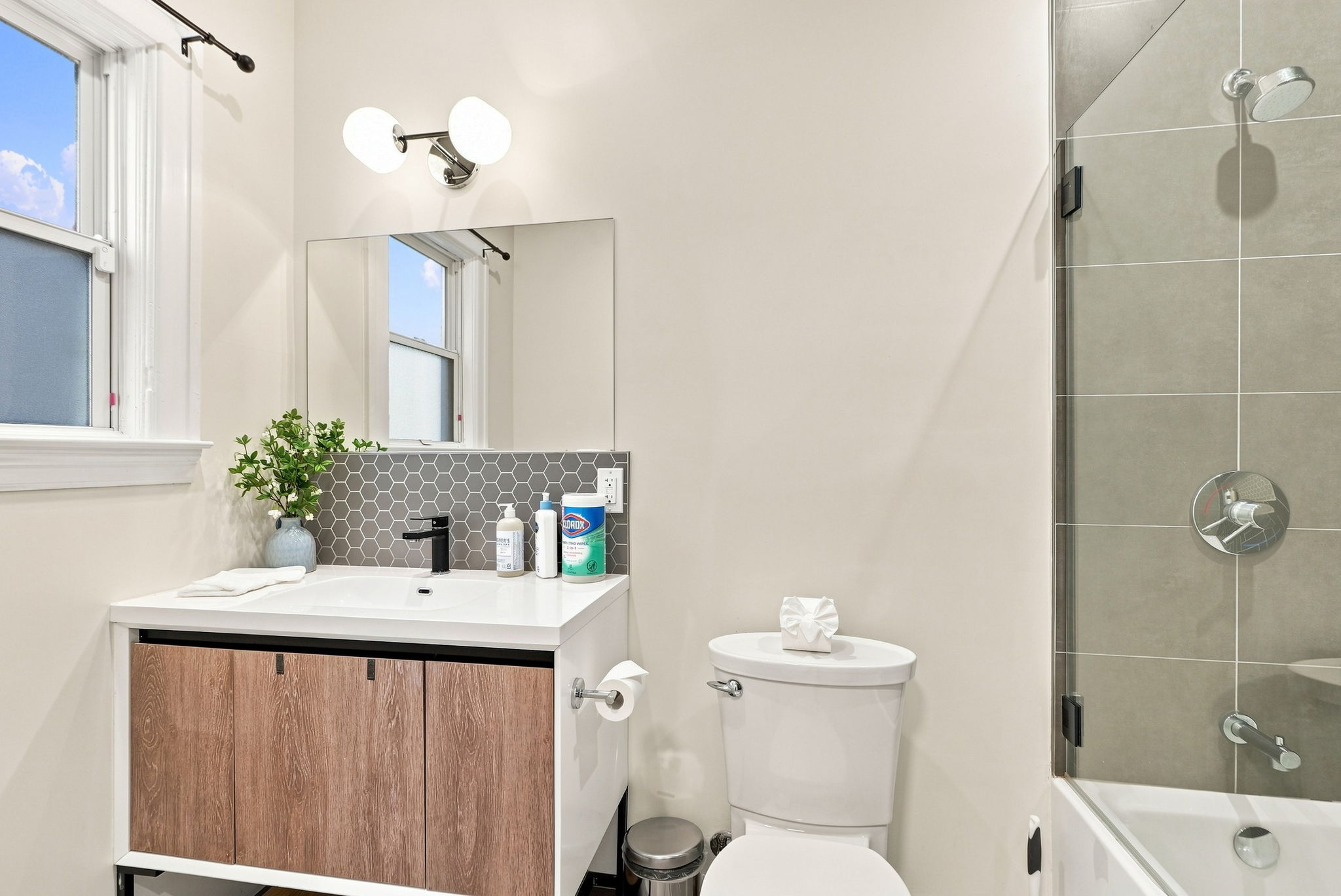 Bright modern bathroom with sleek vanity and tub-shower combo