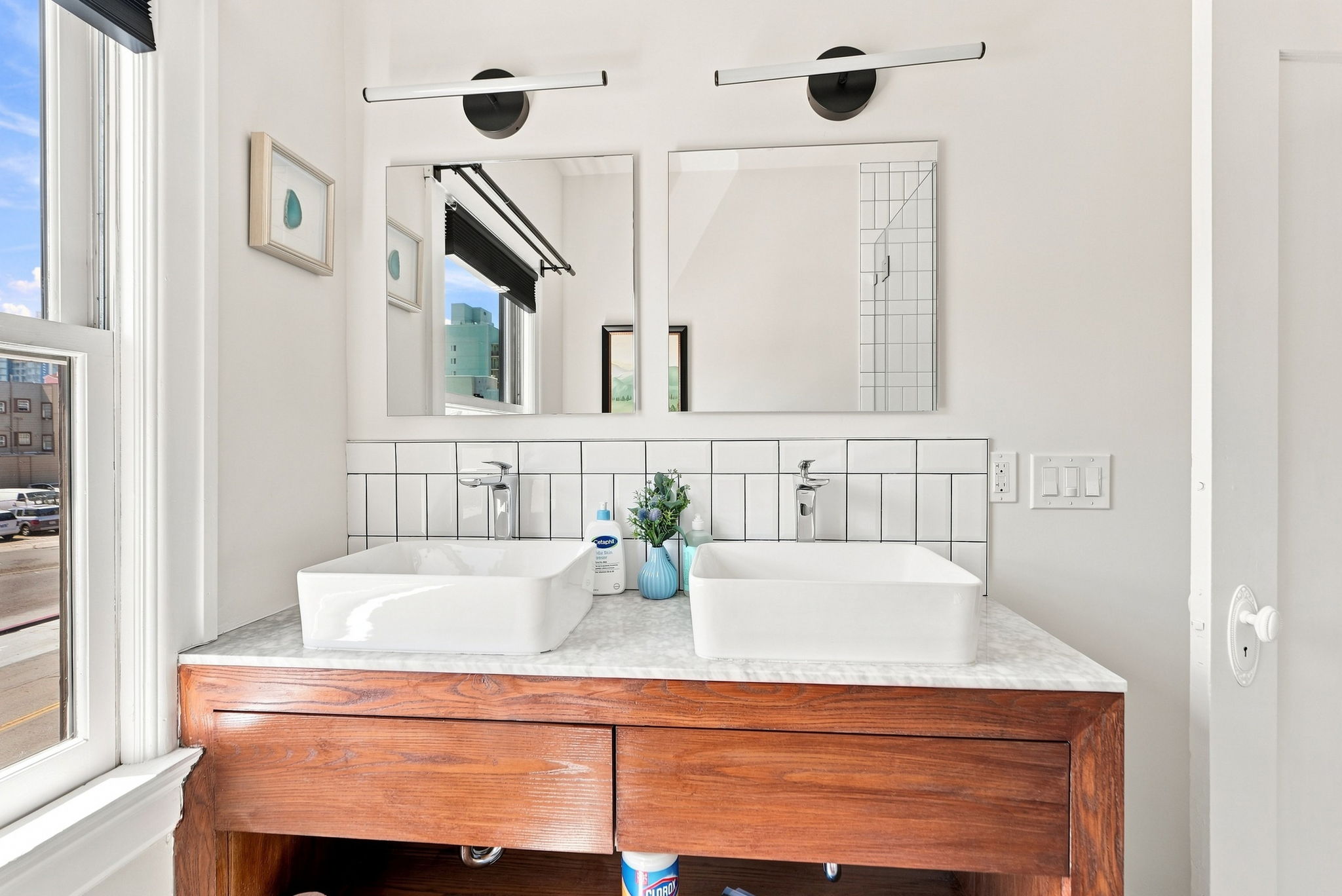 Bright double vanity with modern finishes and plenty of natural light